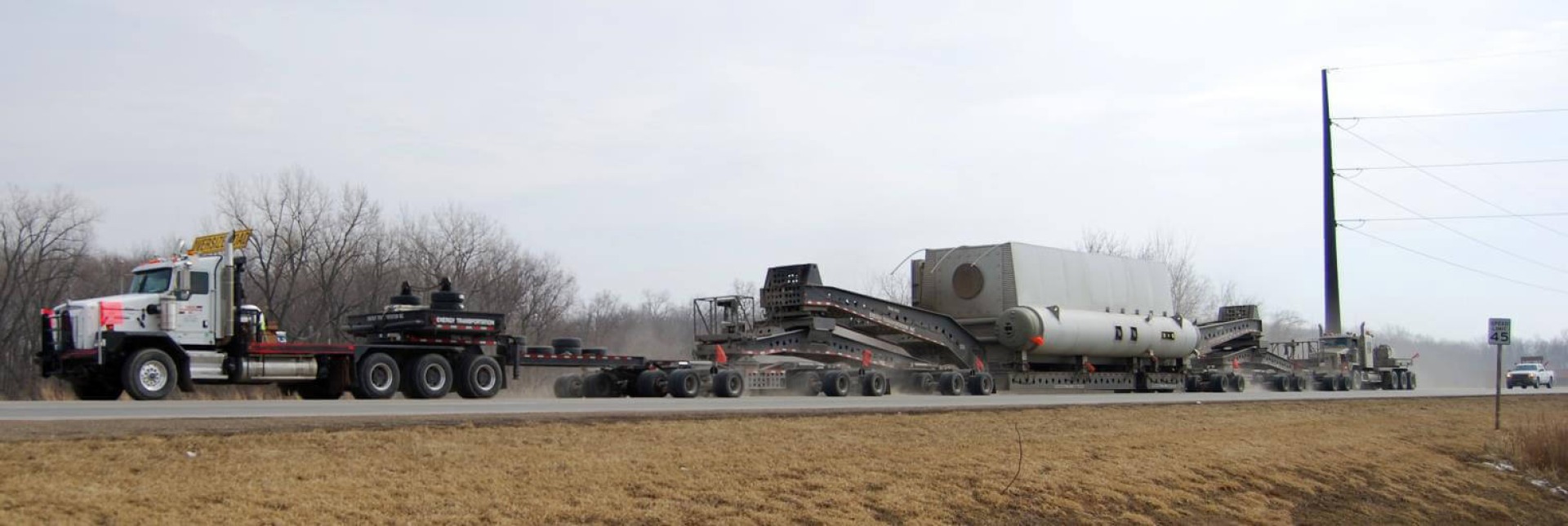 Semi-truck along Winnebago County road towing an oversized/overweight item.